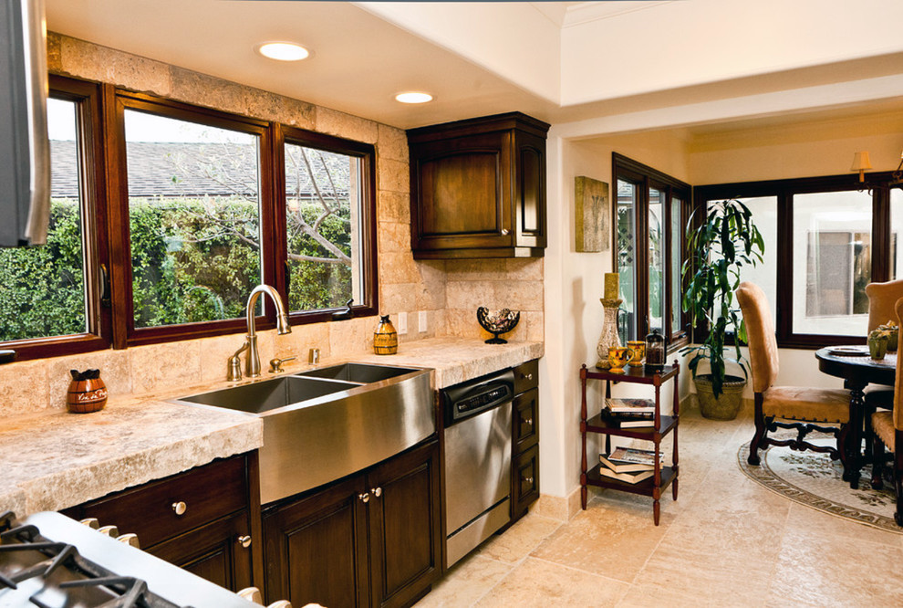 Photo of a large mediterranean u-shaped eat-in kitchen in New York with a farmhouse sink, open cabinets, beige cabinets, limestone benchtops, beige splashback, stone tile splashback, white appliances, limestone floors and with island.