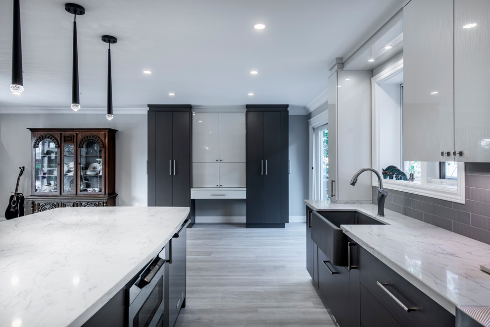 Design ideas for a large modern u-shaped eat-in kitchen in Toronto with a farmhouse sink, flat-panel cabinets, white cabinets, quartzite benchtops, grey splashback, subway tile splashback, stainless steel appliances, vinyl floors, with island, grey floor and white benchtop.