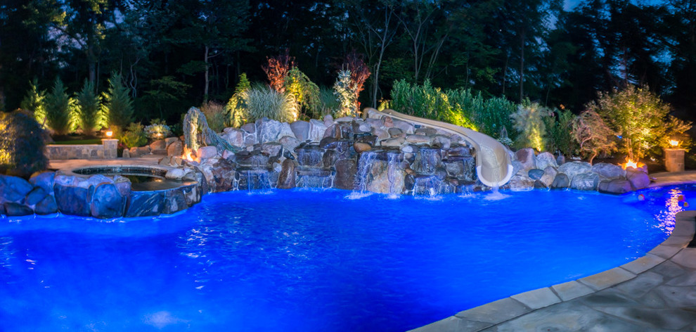 Mid-sized contemporary backyard custom-shaped pool in New York with a water feature and tile.
