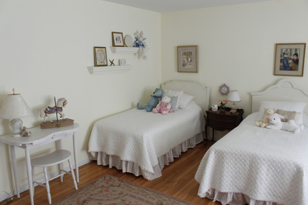 Cette photo montre une chambre de taille moyenne avec un mur blanc et un sol en bois brun.
