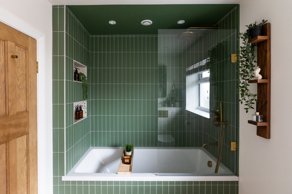 Photo of a medium sized retro family bathroom in Sussex with freestanding cabinets, medium wood cabinets, a built-in bath, a built-in shower, green tiles, porcelain tiles, white walls, terrazzo worktops, multi-coloured floors, white worktops, a single sink and a freestanding vanity unit.