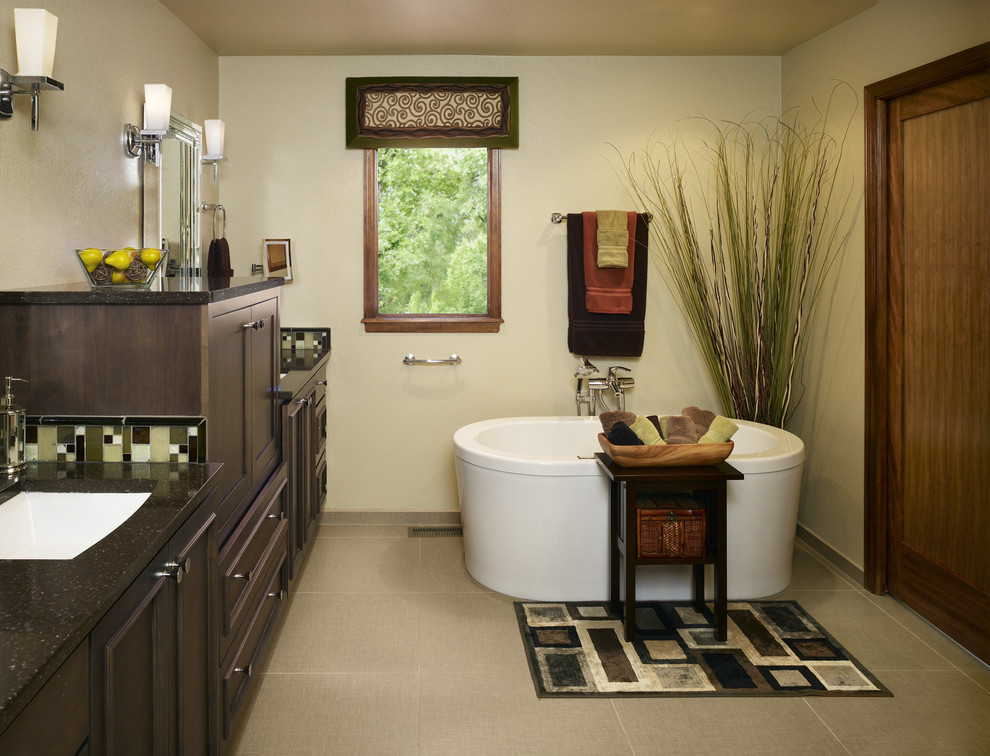 Design ideas for a mid-sized contemporary master bathroom in Denver with beaded inset cabinets, dark wood cabinets, a freestanding tub, a corner shower, a two-piece toilet, green tile, glass sheet wall, yellow walls, porcelain floors, an undermount sink and solid surface benchtops.