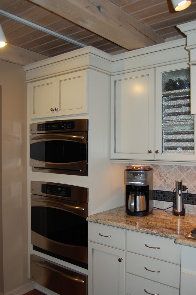 Open concept kitchen - mid-sized transitional u-shaped medium tone wood floor open concept kitchen idea in Chicago with an undermount sink, flat-panel cabinets, dark wood cabinets, granite countertops, beige backsplash, stone tile backsplash, stainless steel appliances and a peninsula