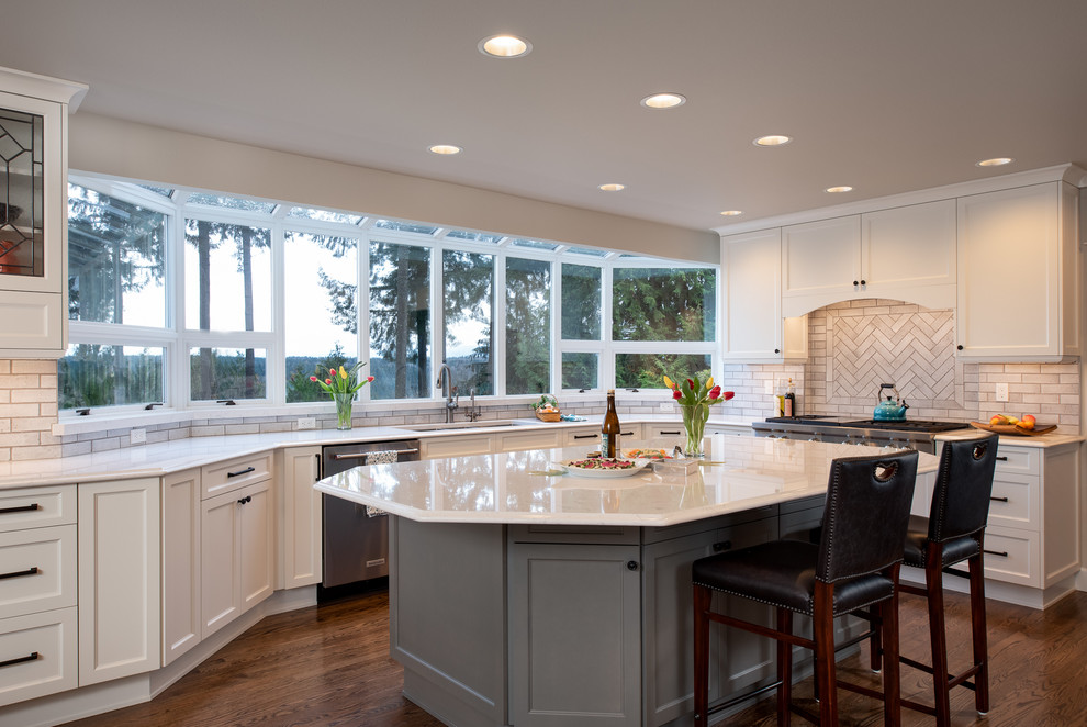 Large traditional u-shaped eat-in kitchen in Seattle with a triple-bowl sink, shaker cabinets, white cabinets, quartz benchtops, beige splashback, ceramic splashback, stainless steel appliances, dark hardwood floors, with island, brown floor and white benchtop.