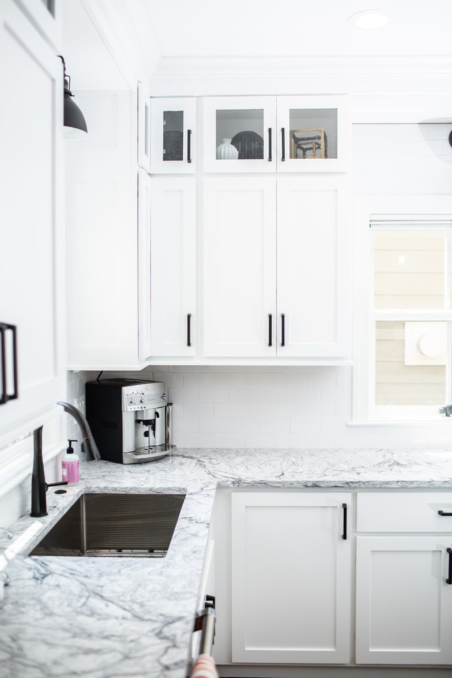 Inspiration for a mid-sized transitional l-shaped eat-in kitchen in Denver with an undermount sink, shaker cabinets, white cabinets, quartzite benchtops, white splashback, subway tile splashback, stainless steel appliances, medium hardwood floors, with island, brown floor and white benchtop.