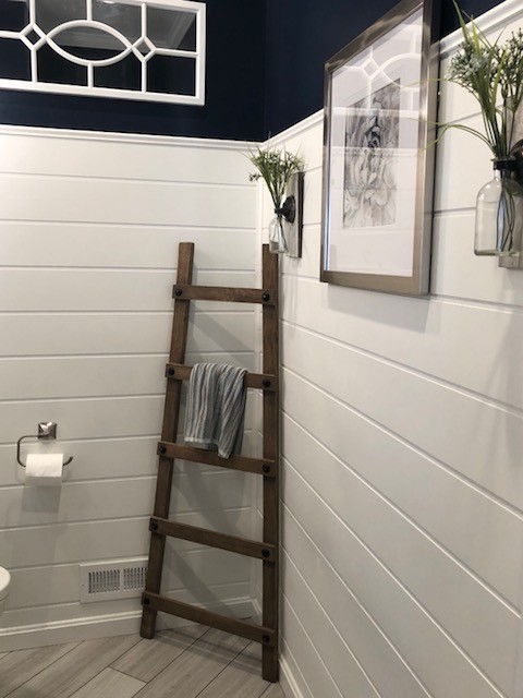 Design ideas for a medium sized classic shower room bathroom in DC Metro with recessed-panel cabinets, black cabinets, a two-piece toilet, blue walls, porcelain flooring, a submerged sink, engineered stone worktops, beige floors and white worktops.