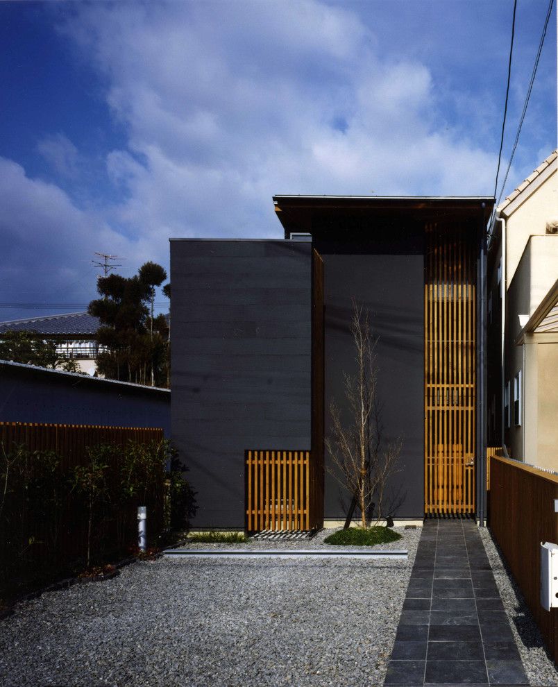 This is an example of a contemporary two-storey black exterior in Kyoto with a flat roof and mixed siding.