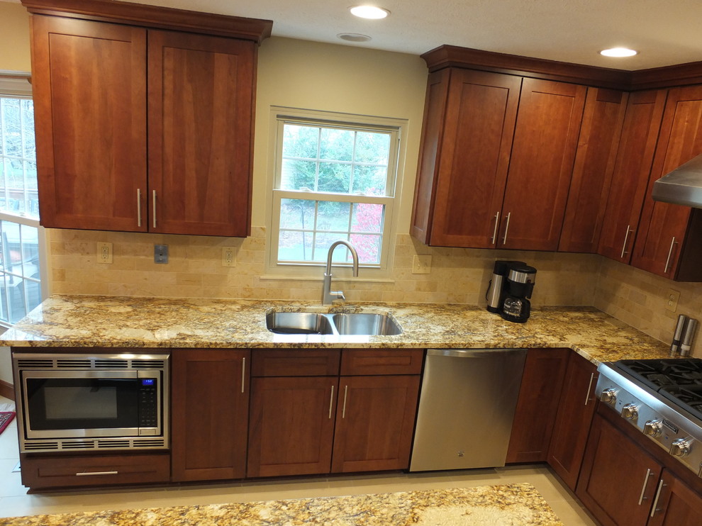 Mid-sized transitional l-shaped ceramic tile eat-in kitchen photo in Columbus with an undermount sink, shaker cabinets, brown cabinets, granite countertops, beige backsplash, ceramic backsplash, stainless steel appliances and an island