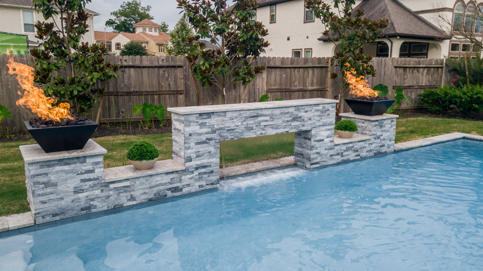 Pool - large contemporary backyard rectangular pool idea in Houston with decking