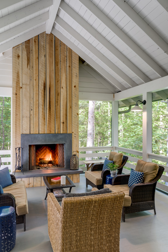 Large cottage back porch idea with a fireplace and a roof extension