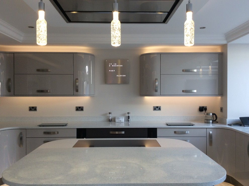 Large contemporary u-shaped kitchen/diner with beige cabinets, granite worktops, black appliances and an island.
