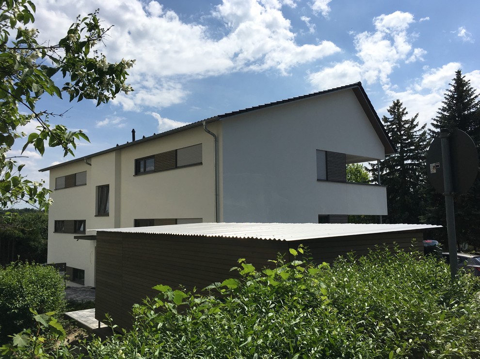 Großes, Zweistöckiges Modernes Einfamilienhaus mit Putzfassade, weißer Fassadenfarbe, Halbwalmdach und Ziegeldach in München