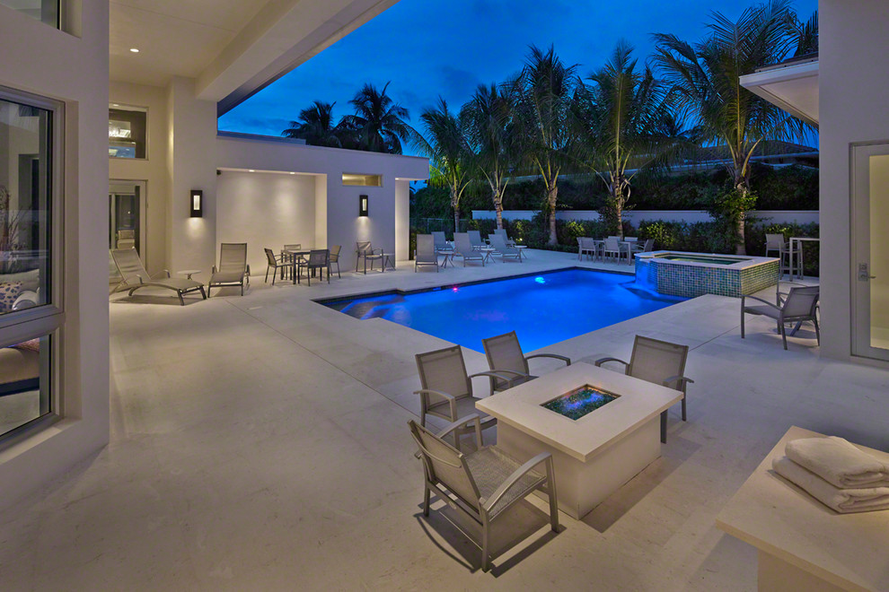 Inspiration for a mid-sized contemporary backyard rectangular natural pool in Miami with a hot tub and concrete pavers.