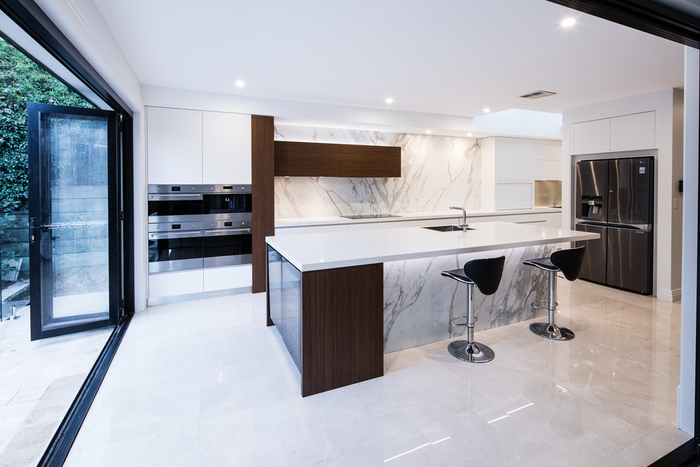 Photo of an expansive contemporary single-wall kitchen in Sydney with an undermount sink, flat-panel cabinets, white cabinets, marble benchtops, glass sheet splashback, stainless steel appliances, porcelain floors, with island, multi-coloured floor and multi-coloured benchtop.