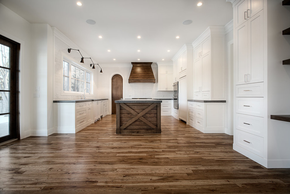 Large transitional u-shaped eat-in kitchen photo in Calgary with shaker cabinets, paneled appliances and an island