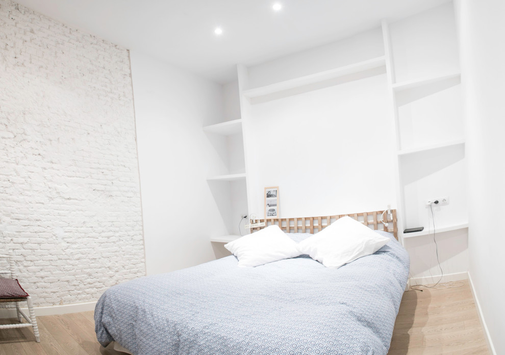 Ejemplo de dormitorio principal escandinavo de tamaño medio sin chimenea con paredes blancas y suelo de madera clara