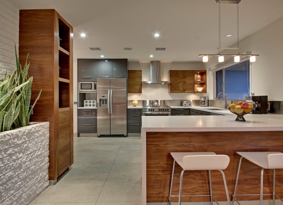 Large midcentury u-shaped eat-in kitchen in Los Angeles with an undermount sink, flat-panel cabinets, grey cabinets, metallic splashback, stainless steel appliances and with island.