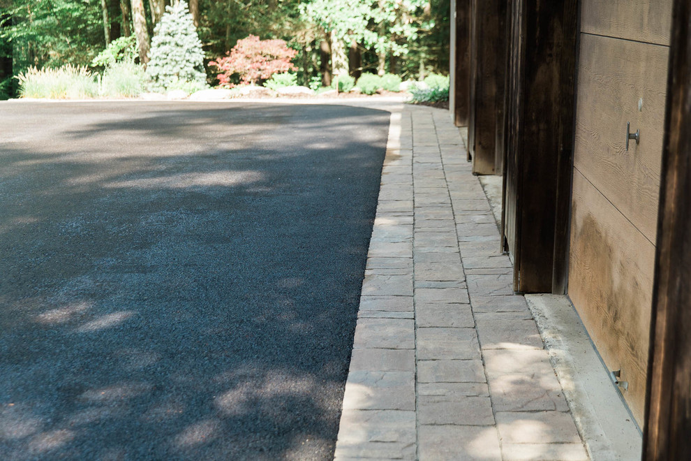 Photo of a small country backyard partial sun driveway in New York with concrete pavers.