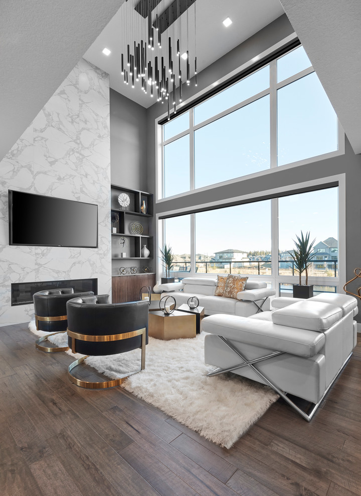 Inspiration for a contemporary living room in Edmonton with grey walls, dark hardwood floors, a ribbon fireplace, a stone fireplace surround, a wall-mounted tv and brown floor.