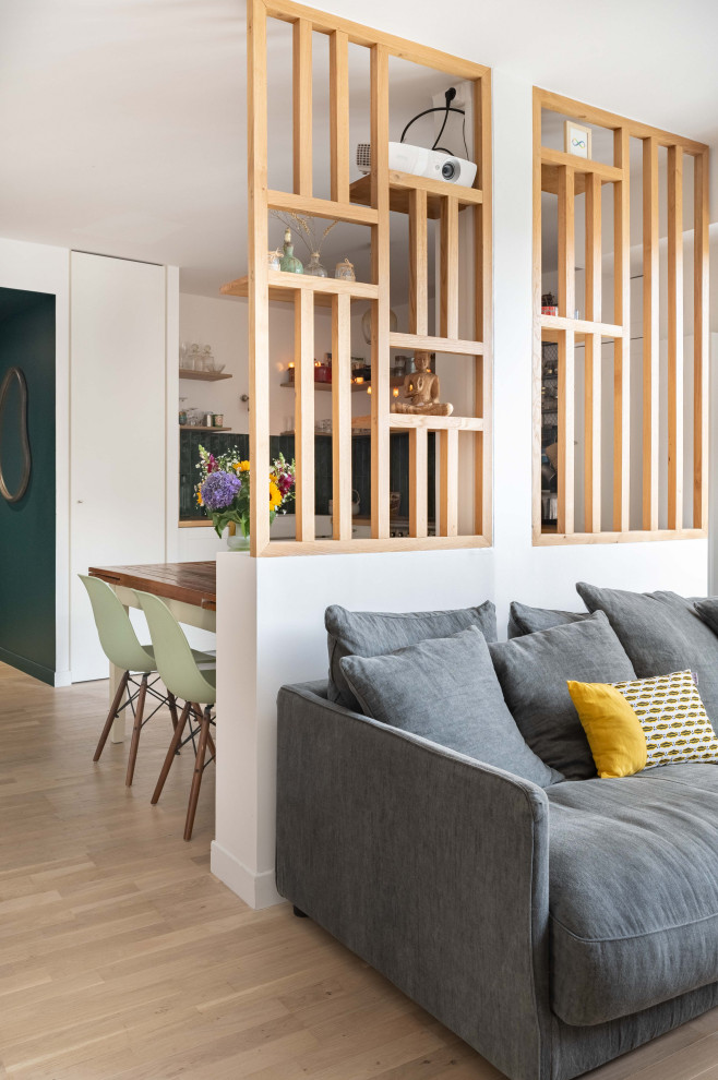 Foto di un soggiorno minimalista di medie dimensioni e aperto con libreria, pareti verdi, parquet chiaro e TV nascosta