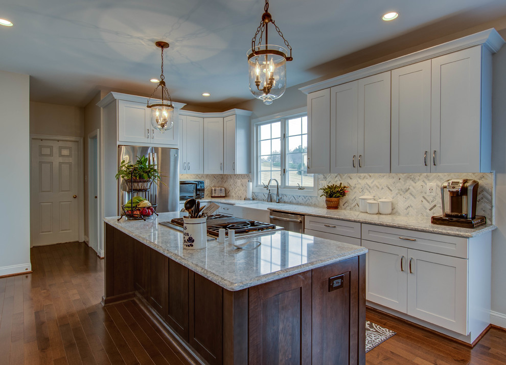 Eat-in kitchen - mid-sized transitional u-shaped dark wood floor and brown floor eat-in kitchen idea in DC Metro with a farmhouse sink, shaker cabinets, white cabinets, stainless steel appliances, an island, gray countertops, quartzite countertops, white backsplash and mosaic tile backsplash