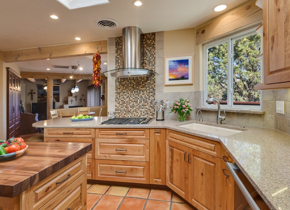 Mid-sized eat-in kitchen in Albuquerque with an undermount sink, raised-panel cabinets, light wood cabinets, grey splashback, stone tile splashback, stainless steel appliances, terra-cotta floors, with island and quartz benchtops.