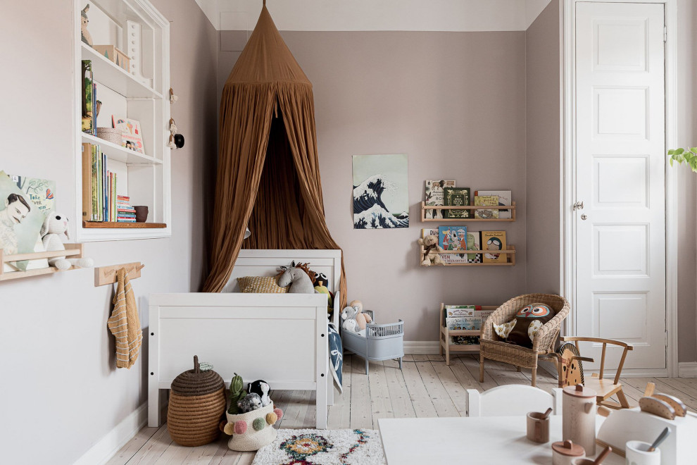 Nordisches Mädchenzimmer mit rosa Wandfarbe, hellem Holzboden, Schlafplatz und beigem Boden in Malmö