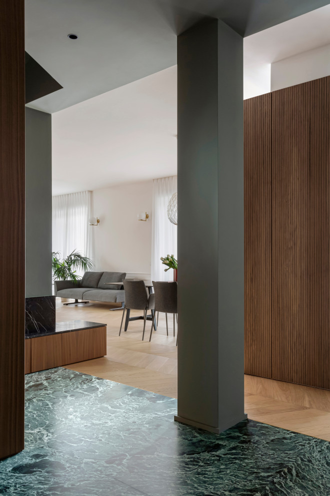 Design ideas for a mid-sized contemporary foyer in Milan with green walls, marble floors, a single front door, a green front door, green floor, recessed and decorative wall panelling.