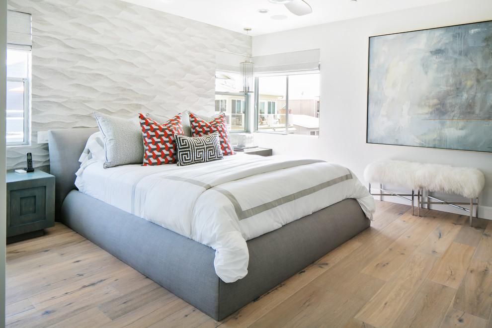 Large contemporary master bedroom in Orange County with white walls and medium hardwood floors.