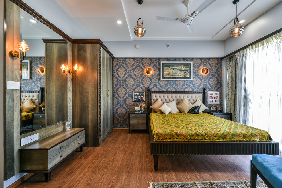 Inspiration for a large modern bedroom in Mumbai with grey walls, medium hardwood floors and brown floor.