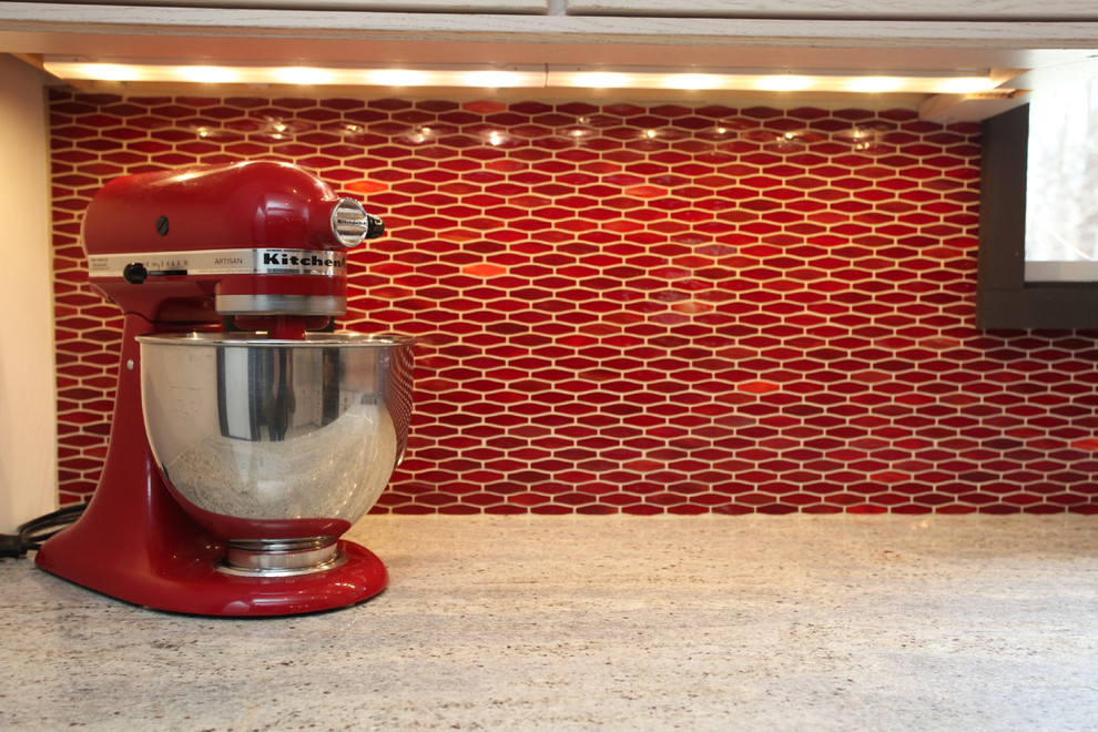 Inspiration for a transitional ceramic tile kitchen remodel in New York with an undermount sink, shaker cabinets, light wood cabinets, granite countertops, red backsplash, ceramic backsplash and stainless steel appliances