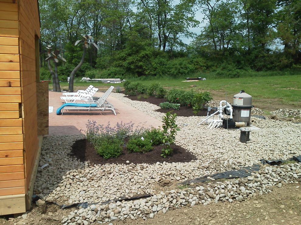 Example of a backyard brick and custom-shaped pool design