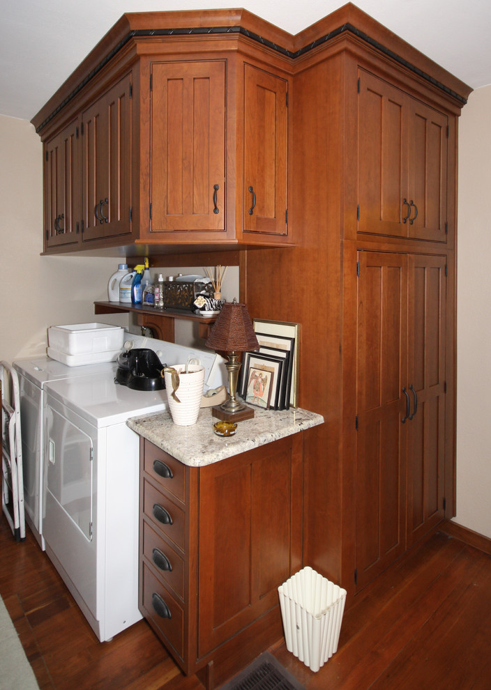 Small arts and crafts l-shaped utility room in Denver with recessed-panel cabinets, medium wood cabinets and a side-by-side washer and dryer.