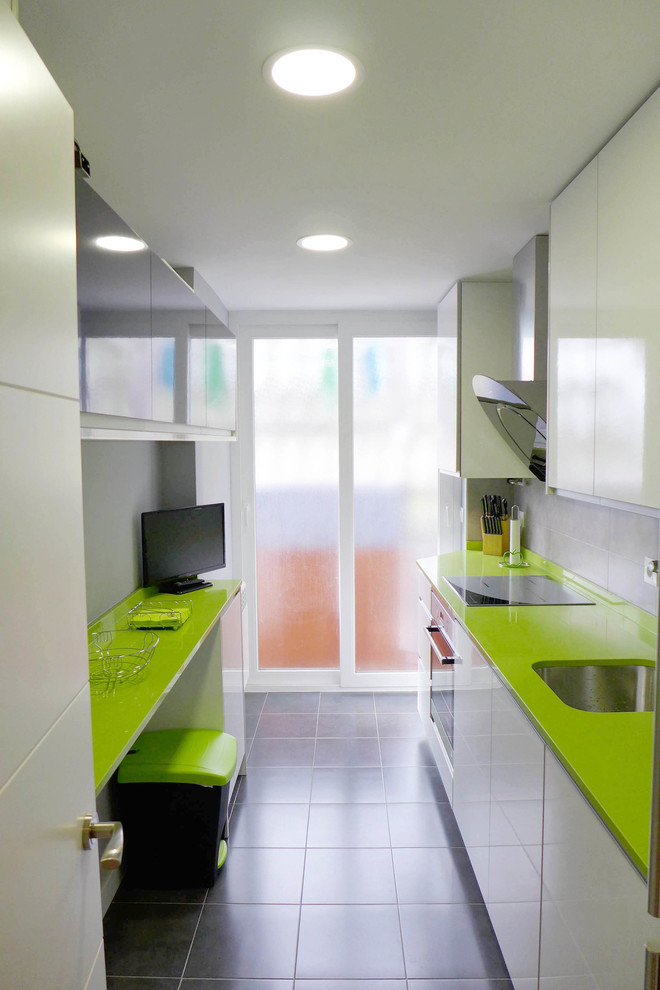 Mid-sized modern galley separate kitchen in Madrid with green benchtop, an undermount sink, flat-panel cabinets, black cabinets, quartz benchtops, grey splashback, porcelain splashback, stainless steel appliances, porcelain floors, no island and grey floor.