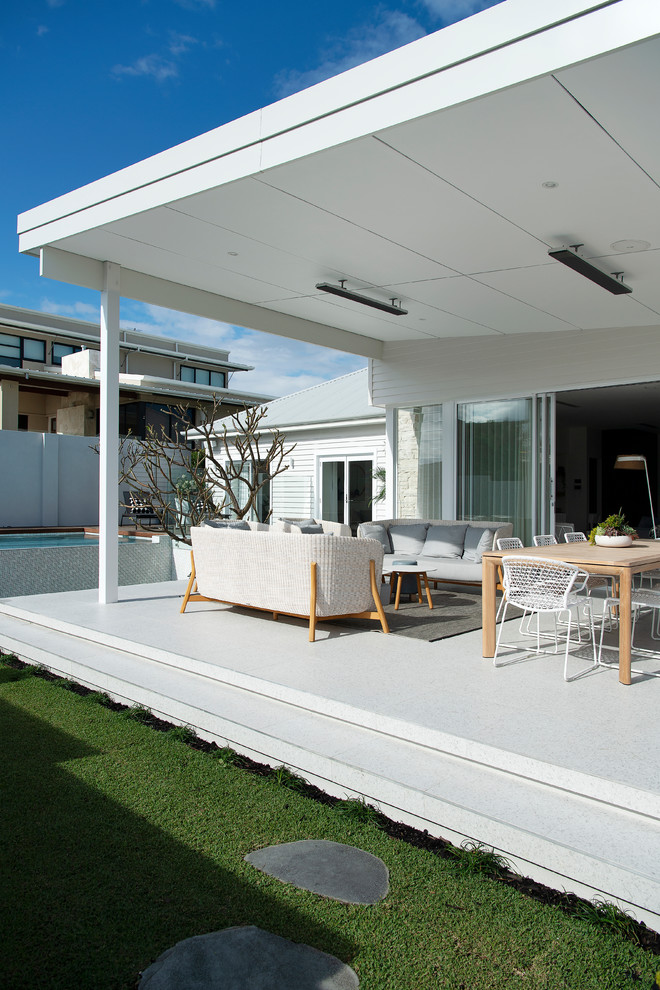 This is an example of a large front yard patio in Perth with tile and a roof extension.