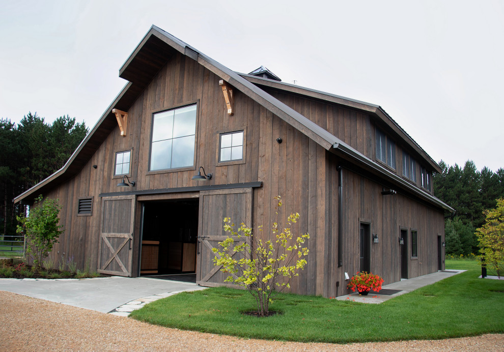 This is an example of a large country two-storey brown exterior in Minneapolis with wood siding, a gable roof and a metal roof.