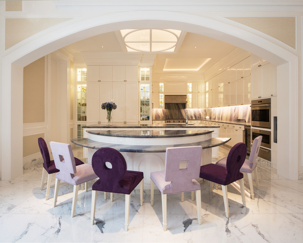Mid-sized transitional l-shaped kitchen in Portland with a double-bowl sink, glass-front cabinets, white cabinets, marble benchtops, marble splashback, stainless steel appliances, marble floors, multiple islands, white floor and purple benchtop.