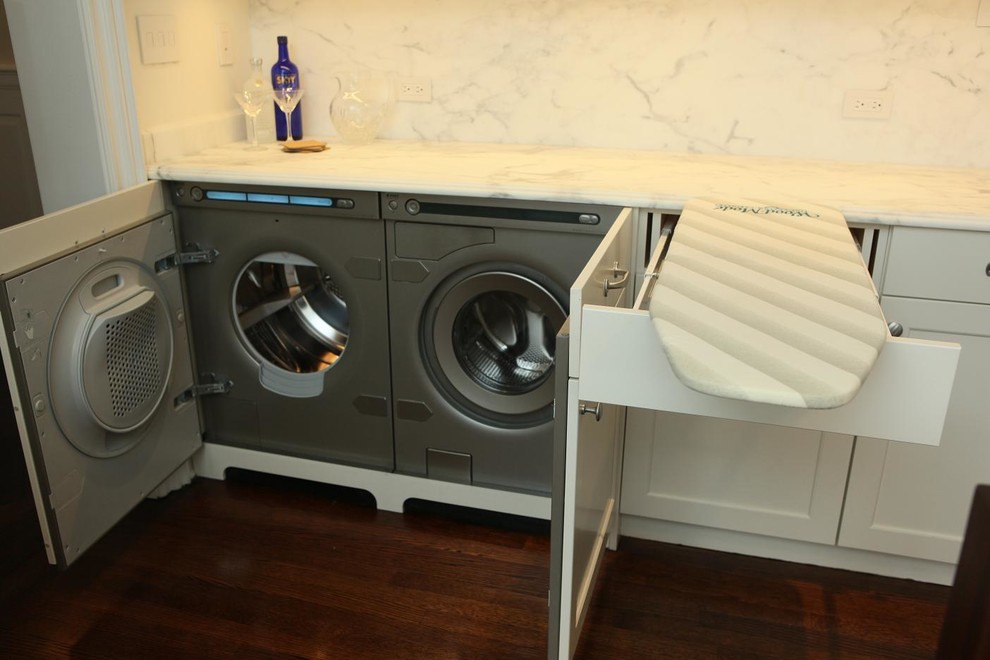 Large traditional u-shaped laundry room in New York with recessed-panel cabinets, white cabinets, marble benchtops, white splashback and stone slab splashback.