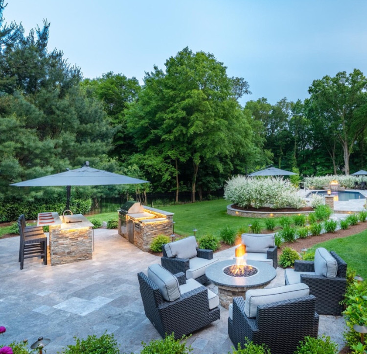 Design ideas for a large transitional backyard patio in New York with a fire feature, natural stone pavers and no cover.