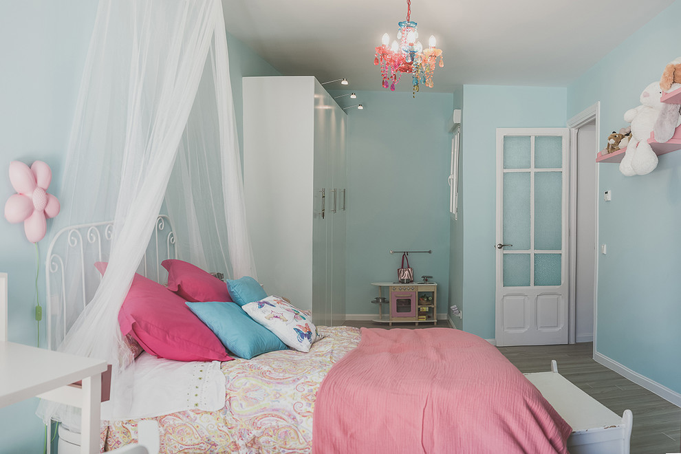 Design ideas for a mid-sized eclectic kids' bedroom for kids 4-10 years old and girls in Madrid with blue walls.