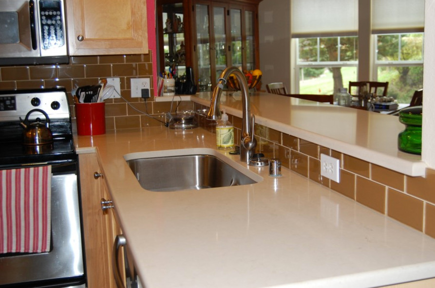 Medium tone wood floor kitchen photo in Seattle with flat-panel cabinets, medium tone wood cabinets, granite countertops, beige backsplash and an island