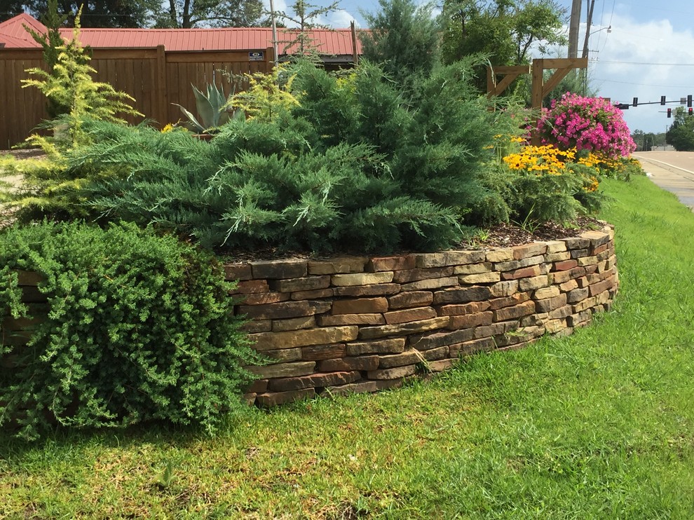 Inspiration for a mid-sized traditional front yard full sun garden for spring in Jackson with a retaining wall and natural stone pavers.