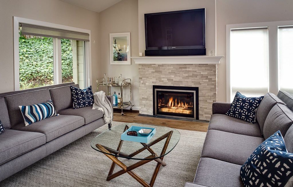 Inspiration for a mid-sized transitional enclosed family room in San Francisco with beige walls, light hardwood floors, a standard fireplace, a tile fireplace surround and a wall-mounted tv.