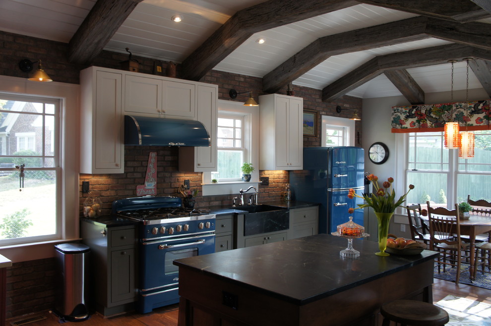 Inspiration for a mid-sized country u-shaped eat-in kitchen in Atlanta with a farmhouse sink, shaker cabinets, white cabinets, coloured appliances, light hardwood floors, with island, soapstone benchtops, brick splashback and brown floor.