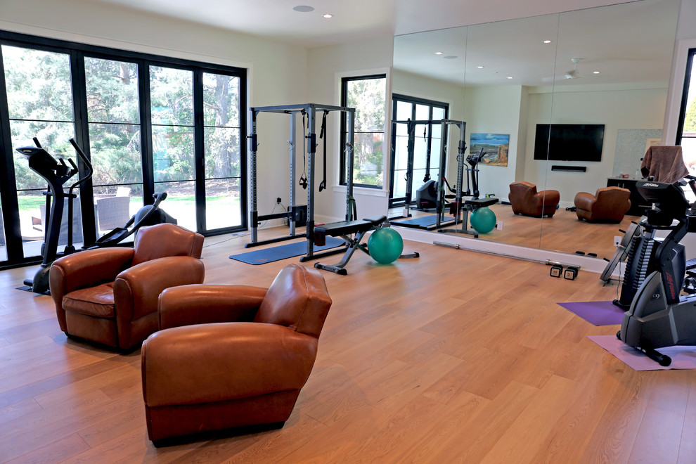 Inspiration for a mid-sized contemporary home weight room in Denver with white walls and light hardwood floors.