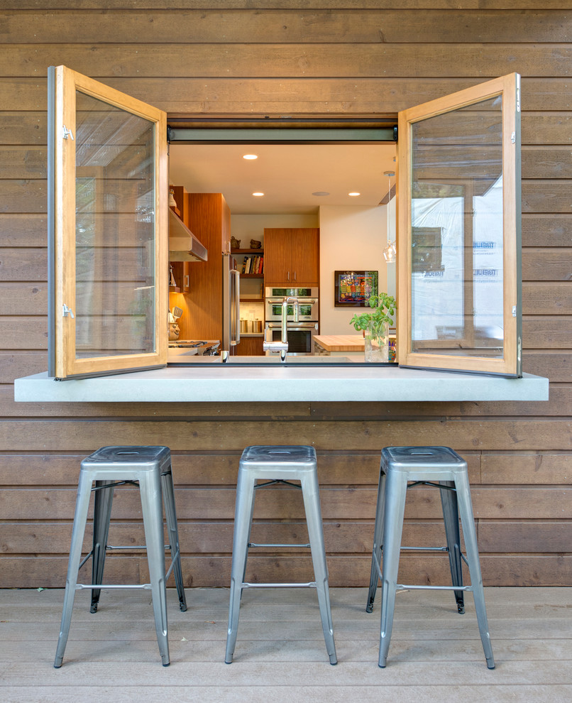 This is an example of a mid-sized modern backyard deck in Seattle with an outdoor kitchen and no cover.