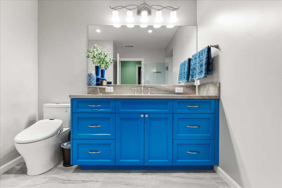 Свежая идея для дизайна: главная ванная комната среднего размера в стиле неоклассика (современная классика) с фасадами островного типа, синими фасадами, серой плиткой, столешницей из кварцита, разноцветной столешницей, тумбой под одну раковину, встроенной тумбой, полновстраиваемой ванной, душевой комнатой, унитазом-моноблоком, керамогранитной плиткой, серыми стенами, врезной раковиной, душем с распашными дверями, полом из керамогранита, серым полом и нишей - отличное фото интерьера
