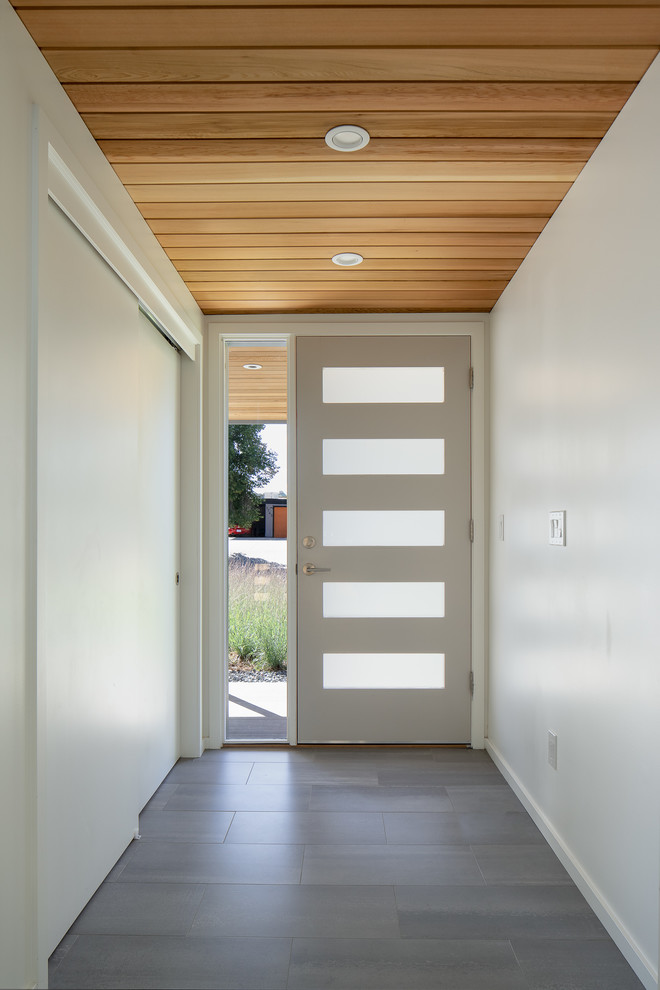 Photo of a mid-sized modern front door in Denver with white walls, ceramic floors, a single front door, a gray front door and grey floor.