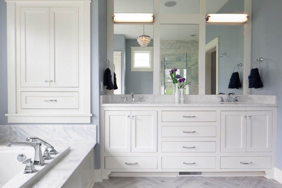 Photo of a large arts and crafts master bathroom in Milwaukee with flat-panel cabinets, white cabinets, a drop-in tub, ceramic tile, blue walls, ceramic floors, an undermount sink, granite benchtops, grey floor, white benchtops, a corner shower and a hinged shower door.