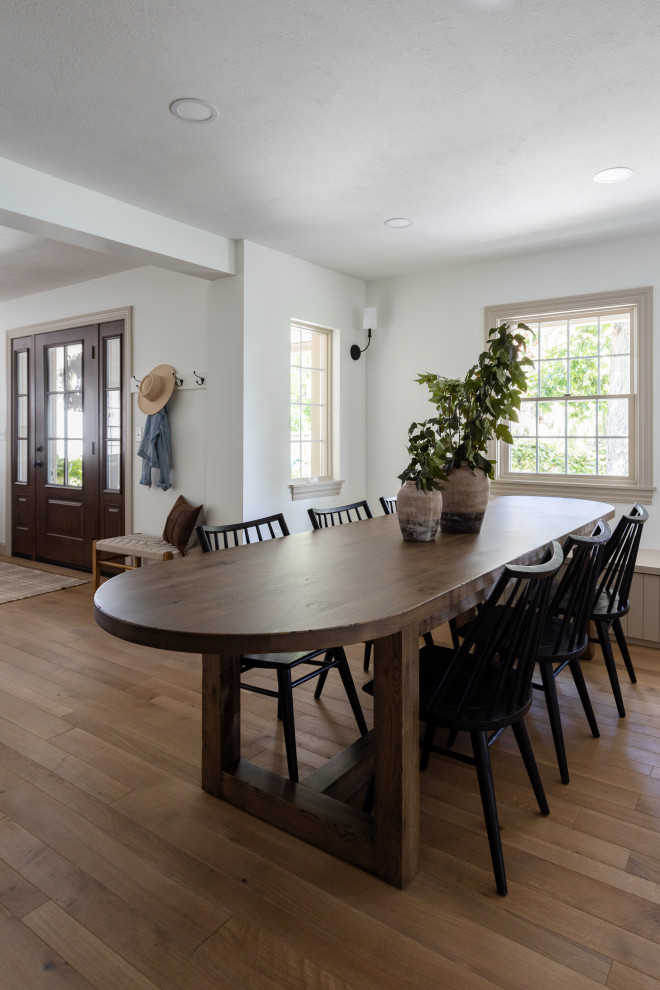Kitchen/dining combo in Cleveland with white walls, medium hardwood floors and brown floor.